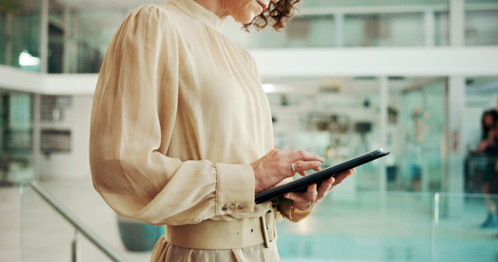 A woman researches her potential employer on an tablet